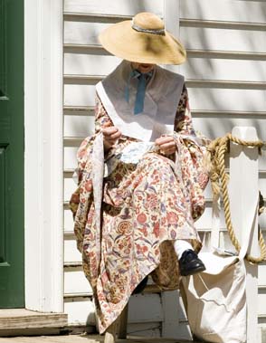 Woman in Colonial Dress sitting outside building