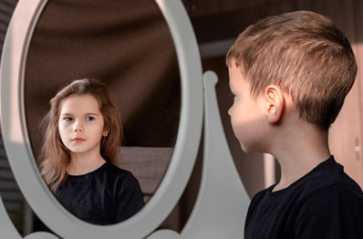 Boy looks into mirror and sees girl