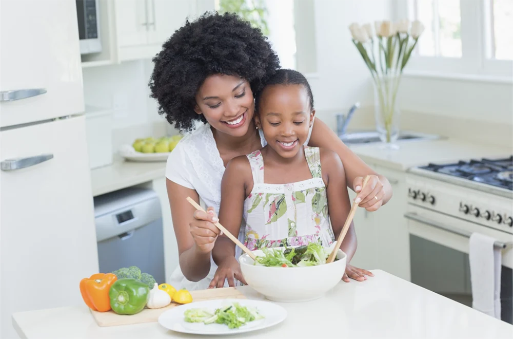 Mother and daughter making salad